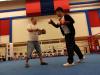 Mok Tsz Kai is practising sparring with the coach. 