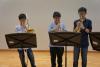 Students are having a rehearsal at the school hall before the performance.