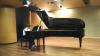 A student is performing a piano piece in a performance hall at Guangzhou Pearl River Piano Group Company.