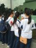 Happy students complete their evaluation forms while hotel diners look on.