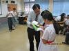 A class teacher is helping one of the students to play the game.