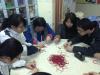 Students are teaching residents how to make the Chinese Ruyi knot.