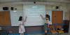Two student helpers are explaining the rules of the game to the S.1 students.