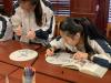 The girl is getting inspiration from the books about Chinese painting.