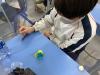 A student was performing the role of a pastry chef. He was making a flower with clay.