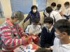 The elderly teaches our students to make a paper lantern.