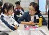 Our student listens to a volunteer from the business sector.