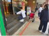 Students are trying to climb the stairs as a wheelchair user facing the difficulty of having no wheelchair access.