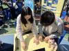 A teacher and a student collaborate to prepare for the competition, ensuring everything is set for a successful and engaging event.
