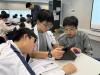 Students learn coding skills with an iPad. 