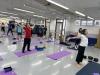Teachers stretch their shoulders and backs under the guidance of the yoga tutor.