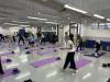 Teachers stretch their waists under the guidance of the yoga tutor.