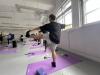 Our teachers stretch their legs under the guidance of the yoga tutor. 