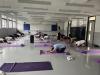 Our teachers stretch their backs under the guidance of the yoga tutor.