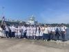 Students are taking photos in front of the warship.