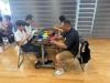 Parents and the kid are working hard to make the handicrafts.