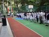 All students are singing the school song together during the flag raising ceremony.