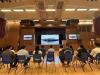 Non-classroom teachers and other colleagues are watching the live broadcast of the military parade in the school hall.
