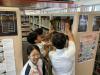 Many students tried to get a book in the bookshelf. 