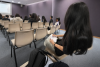 A student is taking notes during the lesson. 