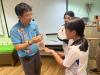 A student is holding an animal on her hand.